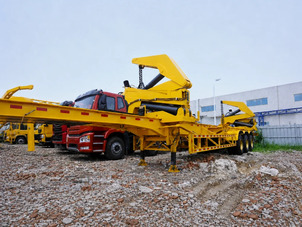 A side loader trailer and tractor unit delivering a container on a bare dirt worksite with hills behind.