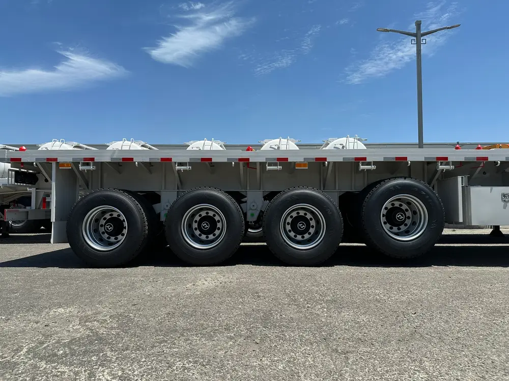 Four HUAYU-brand axles with 16 dual tires carry the 13.7-meter deck of this 45ft flatbed semi trailer.