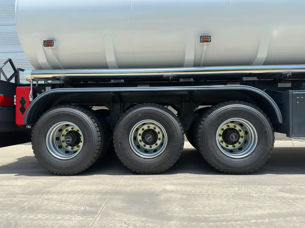 Three 13T FUWA axles on a mechanical leaf-spring stack carry the 40,000L carbon steel tank.