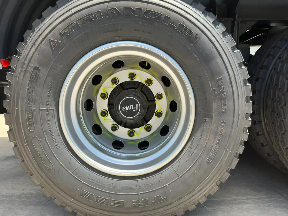 Triangle 12R22.5 tubeless tire on a steel rim with FUWA hub cap and yellow wheel-nut indicators.