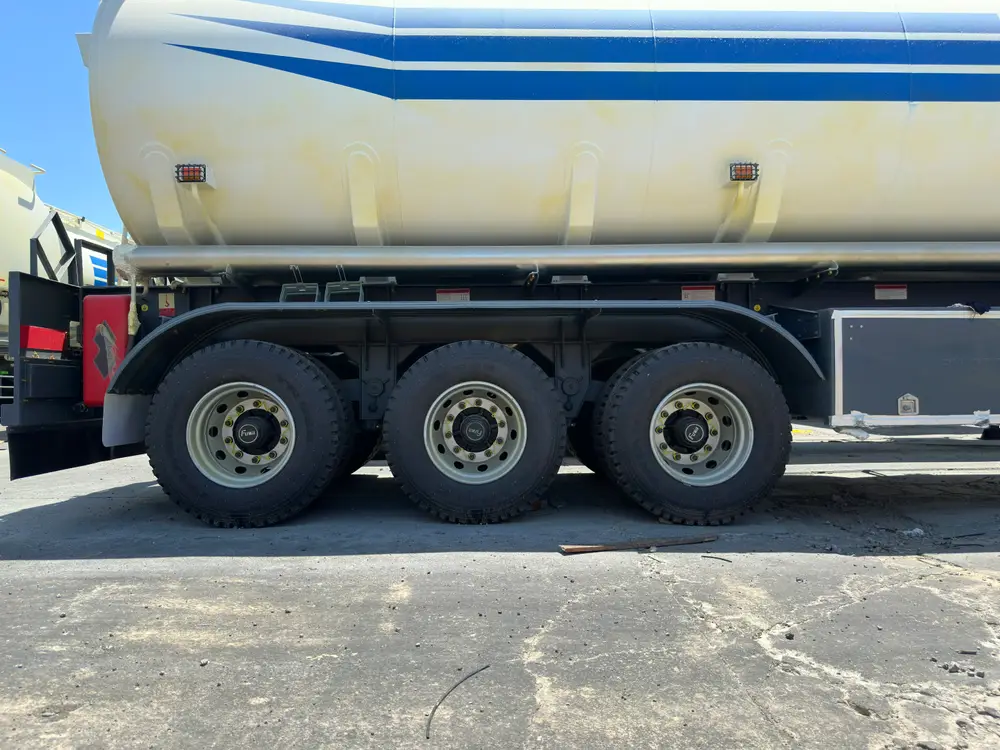 Three FUWA 13T axles with 12R22.5 tires under the carbon steel tank of the 45000L fuel tanker semi trailer.