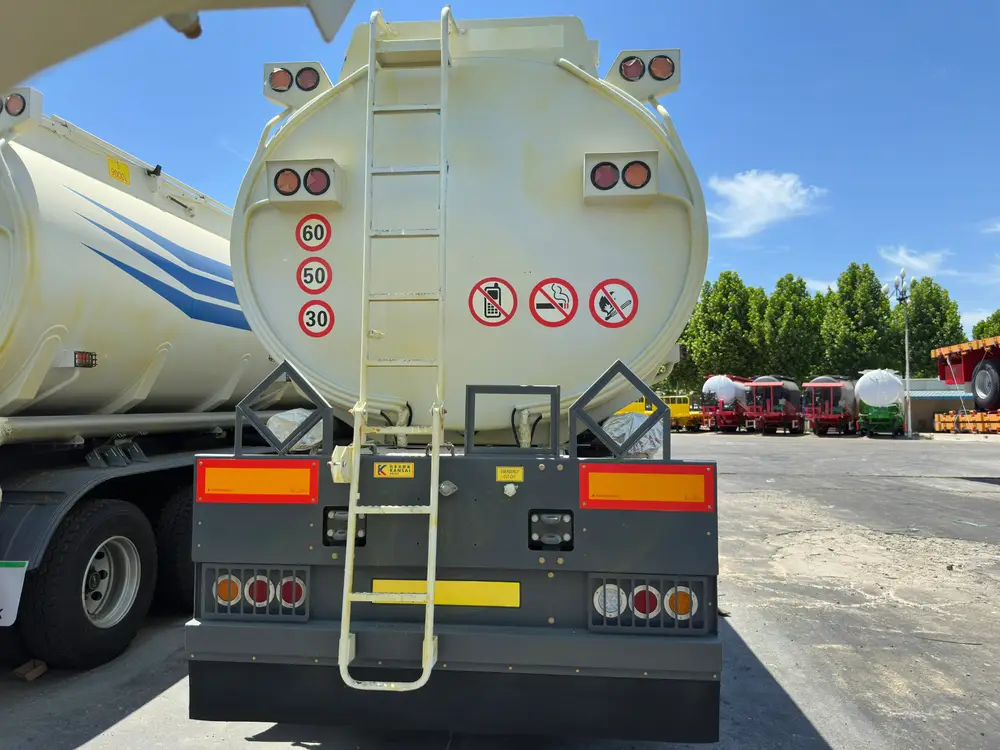 Rear head of the fuel tanker with access ladder, 60/50/30 speed decals, hazard placards, and LED lamp clusters.