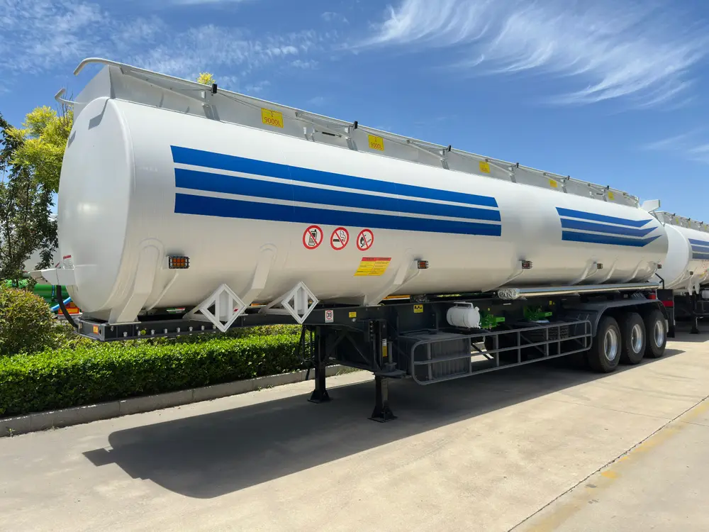 Front three-quarter view of the 3 axle 45000L carbon steel fuel tanker semi trailer, with yellow 9000L plates on the manhole row.