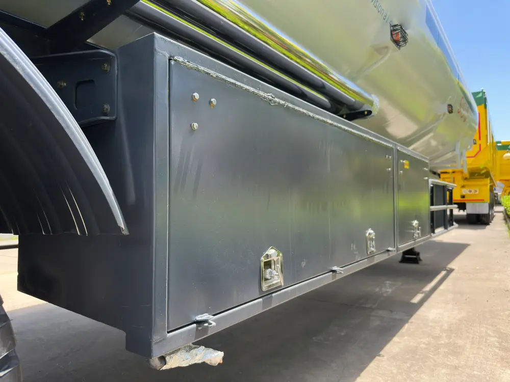 Full-length lockable toolbox mounted on the tanker right side, with the stainless discharge pipe carrier above it.