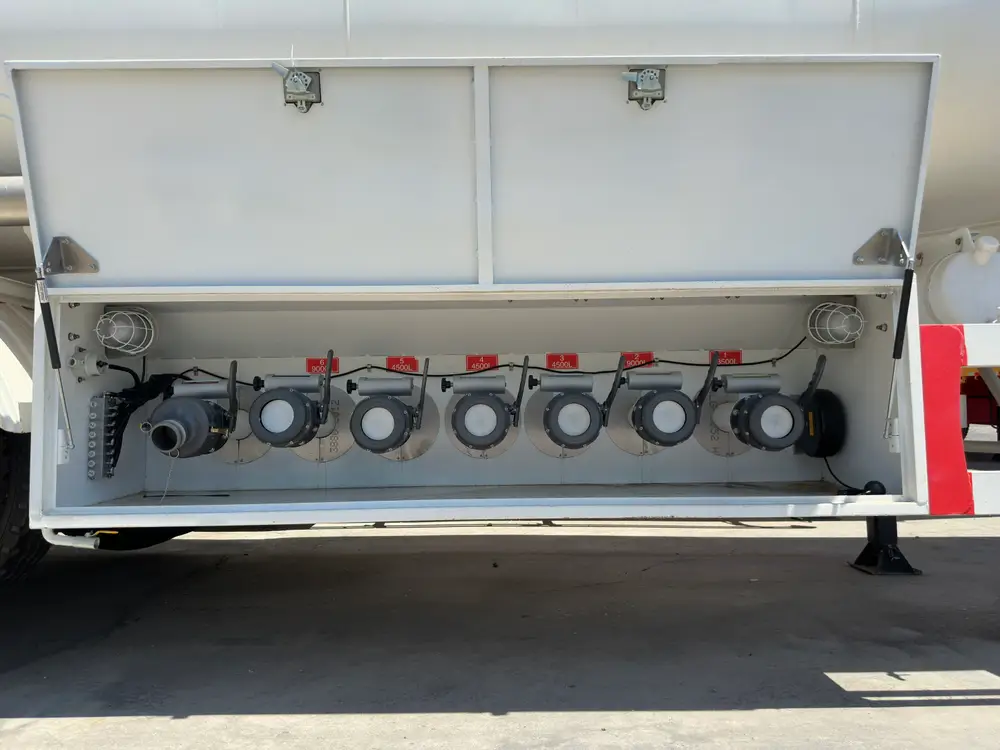 Six API pneumatic bottom valves and a vapor recovery adaptor fill the discharge cabinet of the 4 axle 54000L fuel tanker semi trailer.