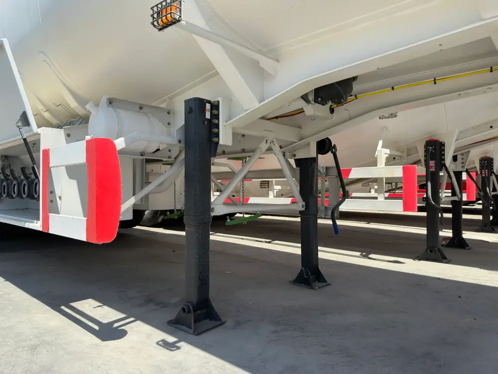 Two-speed landing legs support the tank front beside the discharge pipework and a mesh-caged work lamp.