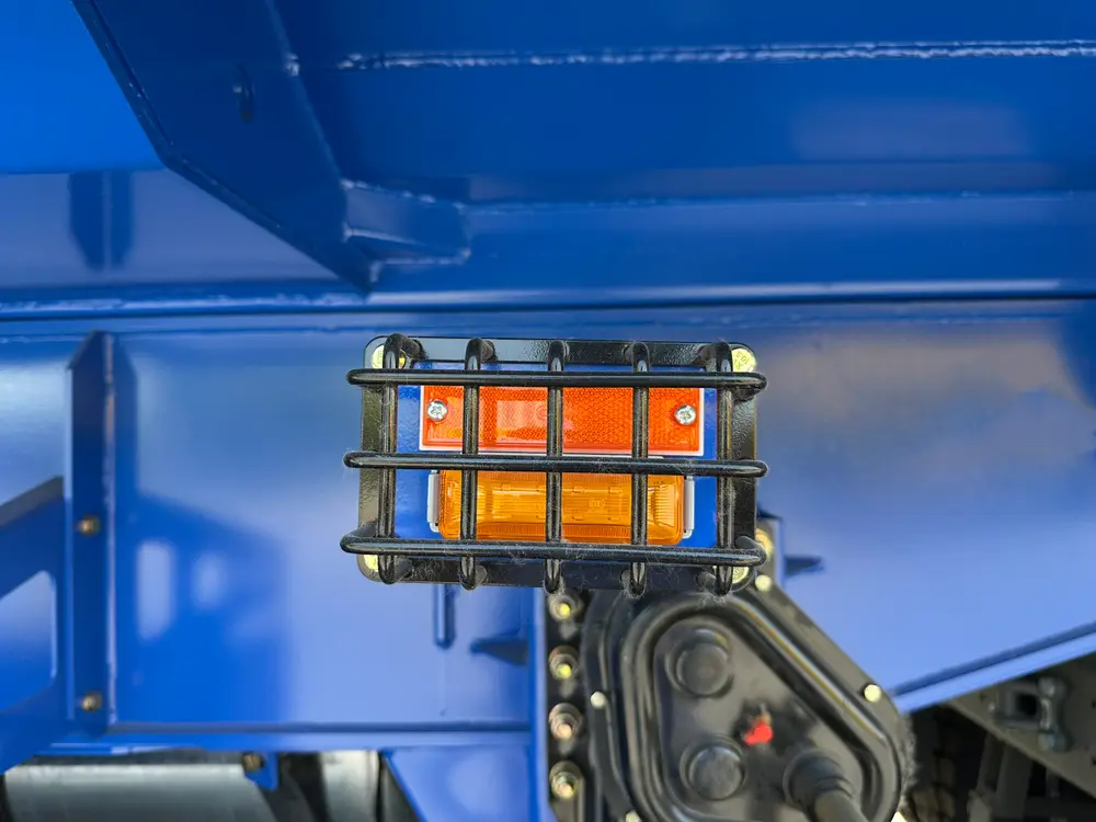 Caged LED side marker lamp mounted on the chassis rail of the mining-spec rear dump trailer.
