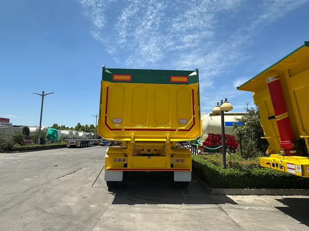Rear view of the 45 CBM mining tipper showing caged tail lamps, conspicuity tape, and white mud flaps.