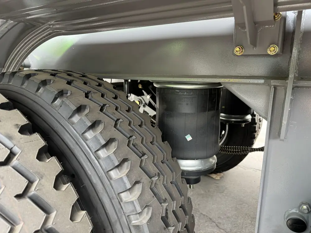 Air suspension bellow close-up under 4 axle rock body dump chassis