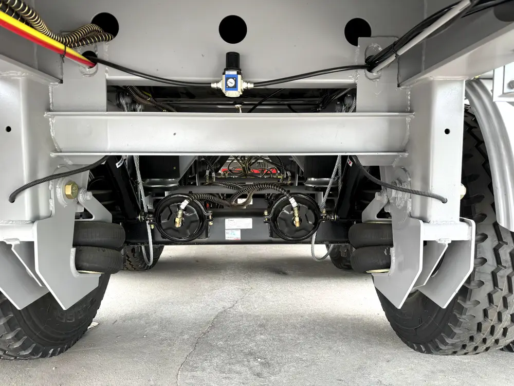 Underside view of 4 axle dump trailer showing air tank brake lines and cross members