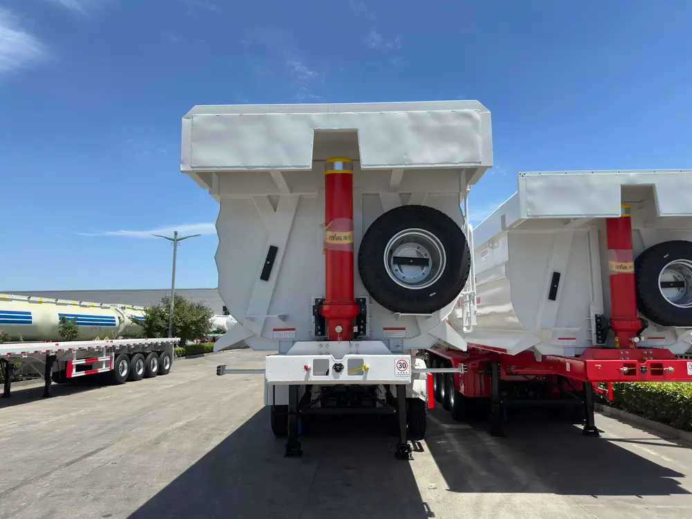The side body of a 4 axle wear-resistant steel tipper semi trailer showing pressed ribs, the BAOSTEEL wear-steel plate, and four FUWA axles.