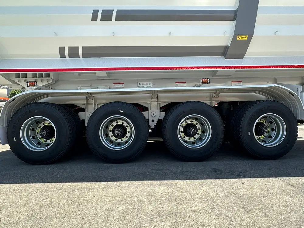 Cross-braced 28T two-speed landing legs and the chassis frame underside of the 4 axle dump semi trailer.